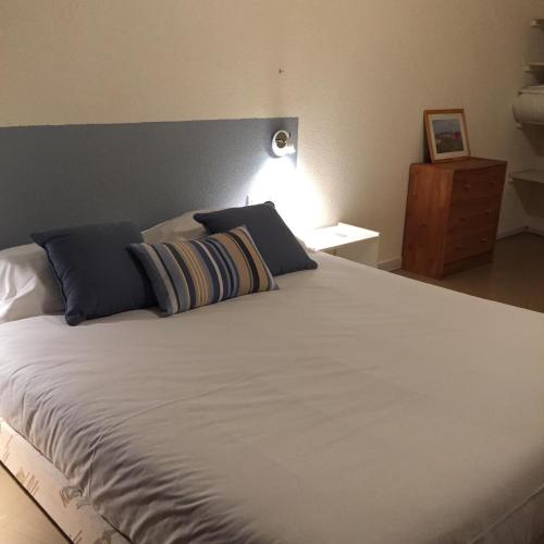 a bedroom with a large white bed with blue pillows at Résidence Thibaud in Toulouse