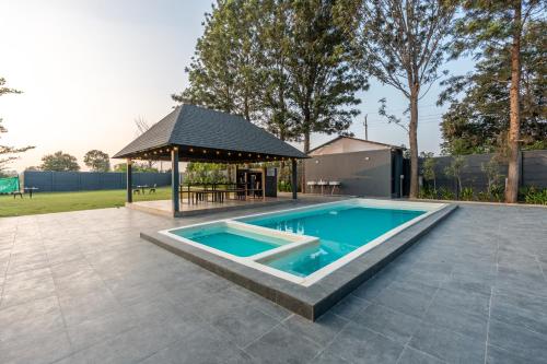 a swimming pool with a gazebo in a backyard at Alaya stays Inara Retreat 1-Cottage with a Mezzanine Loft, Shared Pool, and Garden in Bangalore