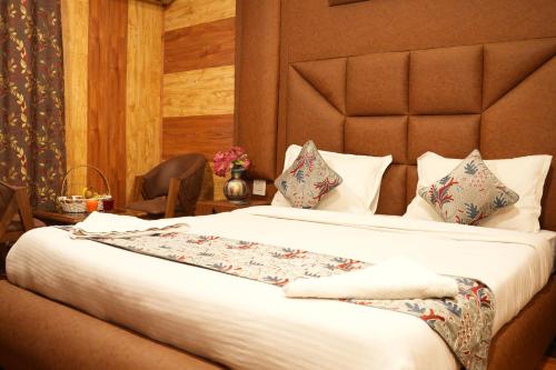 a hotel room with a large bed and a chair at Hotel Park Plaza Srinagar in Srinagar