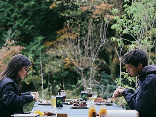 a man and woman sitting at a table eating food at GEOSPOT Motohakone C 2026年1月 New Open in Hakone