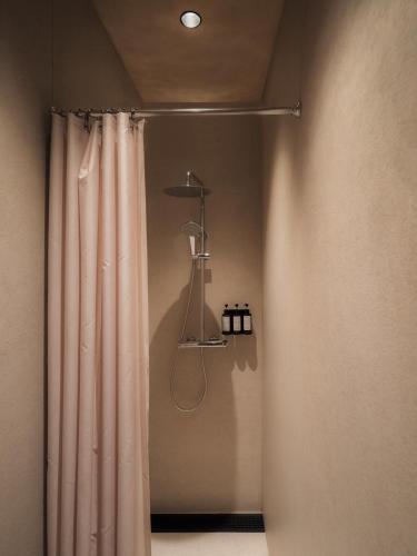 a shower with a shower curtain in a bathroom at GettSleep Madrid Airport T4S - Boarding Pass Required in Madrid