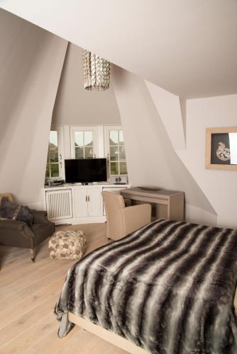 a bedroom with a bed and a tv in it at Rantum Lodge in Rantum