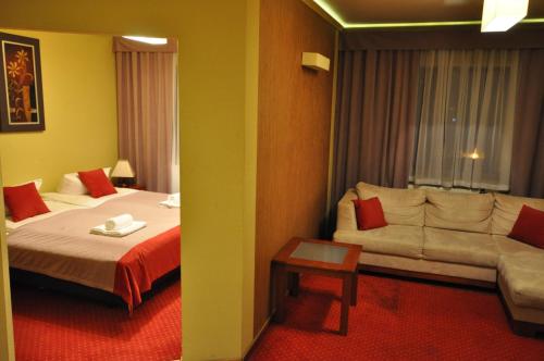 a hotel room with a bed and a couch at Pass Hotel in Zebrzydowice