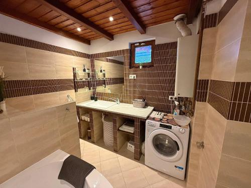 a bathroom with a washing machine and a sink at Erika's House. in Érd