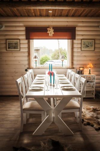a dining room with a white table and chairs at Lammasmäe Puhkekeskus in Linnuse