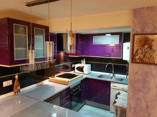 a kitchen with purple cabinets and a sink at Balandra Flat in Valencia