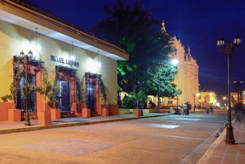 une rue dans une ville la nuit avec un bâtiment dans l'établissement Hotel Libano, à León