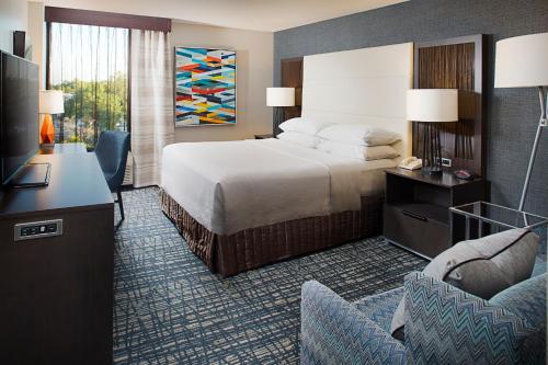 Cette chambre comprend un lit, un bureau et une télévision. dans l'établissement Crowne Plaza Annapolis, an IHG Hotel, à Annapolis