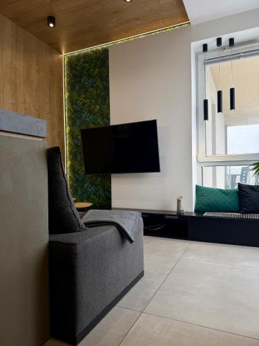 a living room with a tv and a chair at ALEKSANDRA 5 - Leaf in Kielce