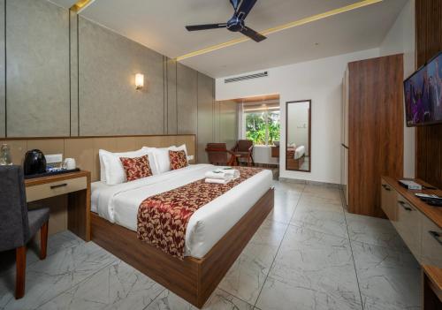 a hotel room with a bed and a desk and chair at Boulevard Premium Luxury Hotel in Munnar