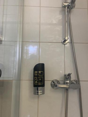 a clock on the wall of a shower at Hotel Schwarzes Ross Siebenlehn in Siebenlehn