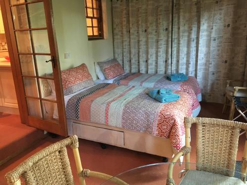 a bedroom with a bed and two wicker chairs at Kentia Palms in Old Reynella