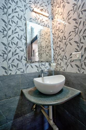 a bathroom with a white sink and a mirror at Baga Riverview 2BHK Mayonna Apartment in Baga