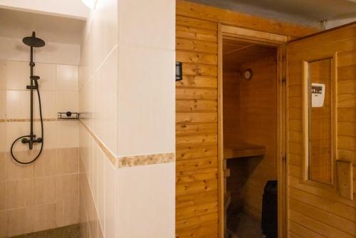 a bathroom with a walk in shower next to a door at Hotel Skála in Malá Skála