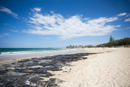 a beach with the ocean and people on it at BreakFree Alexandra Beach in Alexandra Headland