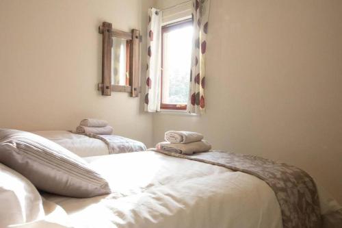 a bedroom with two beds with towels on them at South Groathill - Lovely 2 bed with Castle View in Edinburgh
