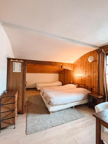 a bedroom with two beds in a room with wooden walls at Hotel Le Genepy in Tignes