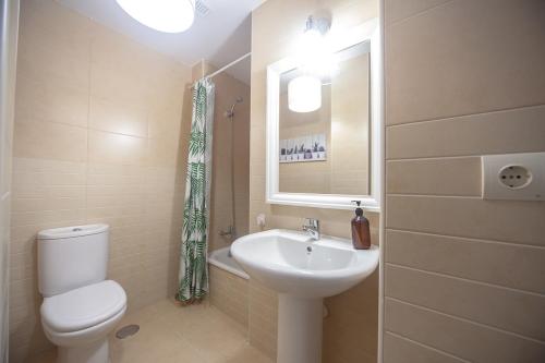 a bathroom with a sink and a toilet and a mirror at La Casa del Columpio, Comillas in Comillas