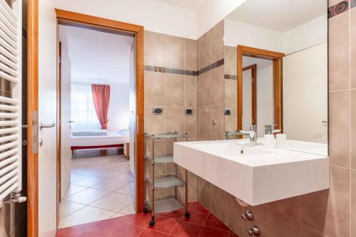 a bathroom with a large white sink and a mirror at Cesa Primula in Canazei