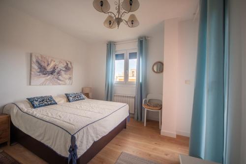 a small bedroom with a bed and a window at La Casa del Columpio, Comillas in Comillas