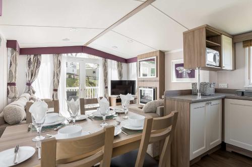 a kitchen and dining room with a table and chairs at Hotel du Van - Rockley Park Caravan, Activities On-site in Poole