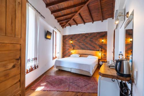 Un dormitorio con una cama y una pared de ladrillo. en Amazon Petite Palace, en Selçuk