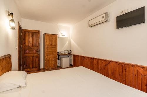 a bedroom with a bed and a tv on the wall at Amazon Petite Palace in Selçuk