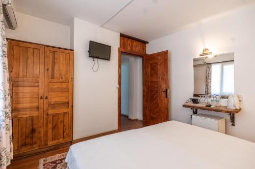 a bedroom with a white bed and wooden cabinets at Amazon Petite Palace in Selcuk
