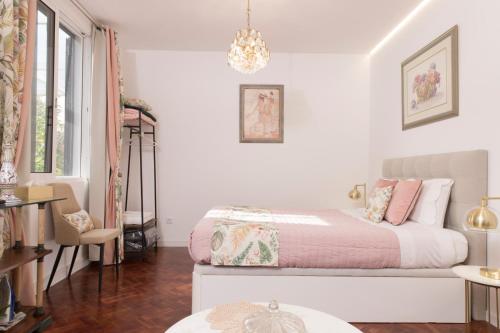 a white bedroom with a bed and a chandelier at Rochinha Cozy Home in Funchal