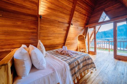 a bedroom with a bed in a wooden room at The Dewi Tasik Kintamani Cabin and Villa in Kubupenlokan