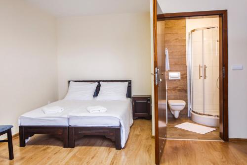 a bedroom with a bed and a bathroom with a shower at BABIOGÓRSKA B&B in Zubrzyca Górna