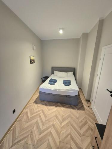 a bedroom with a bed and a wooden floor at Apartament Mickiewicza 3 in Września
