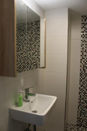 a white bathroom with a sink and a shower at Bungalow Schönblick in Pirna