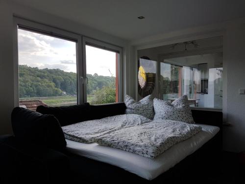 a bed in a room with a large window at Bungalow Schönblick in Pirna