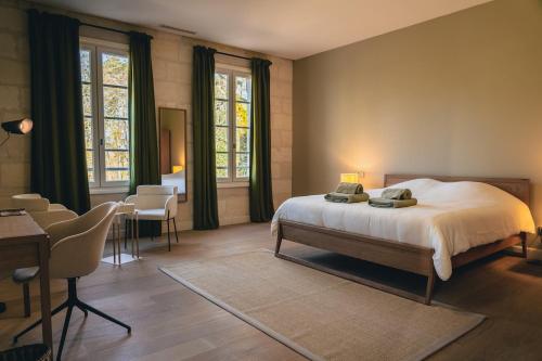 una camera da letto con un letto, un tavolo e delle sedie di Château Moncets a Néac