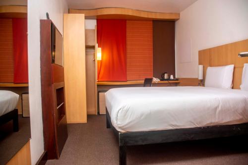 a hotel room with a bed and a desk and a room at Delta Continental Hotel and Suite, Lagos in Lagos