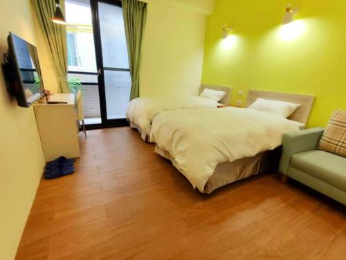 a hotel room with two beds and a couch at Donghae13.8 in Longjing