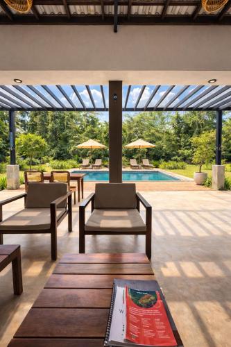 a patio with tables and chairs and a swimming pool at Maho Boutique Hotel in Anuradhapura