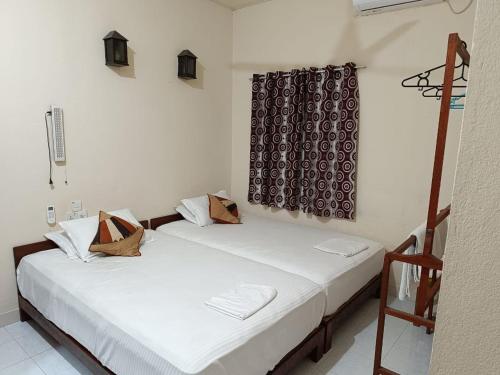 due letti in una stanza con pareti bianche di Tropical Lodge a Hanimaadhoo