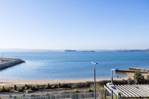a view of a large body of water with a pier at Island's Edge- Moments from Hamworthy Beach and Park in Poole