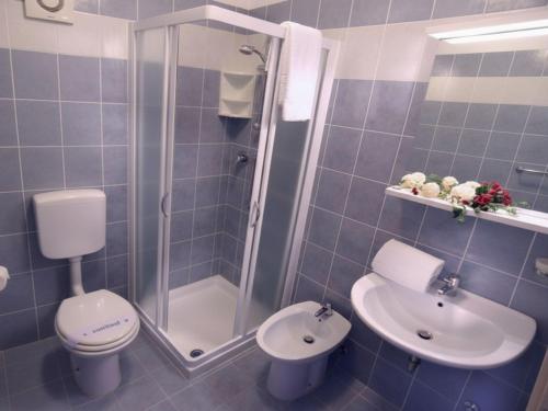 a bathroom with a shower and a toilet and a sink at Residence Silver Sail in Bibione