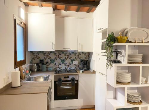 a kitchen with white cabinets and a sink at Calsina Baix 2H in Pals