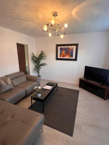 a living room with a couch and a table at Kelpies Serviced Apartments- Russell in Falkirk