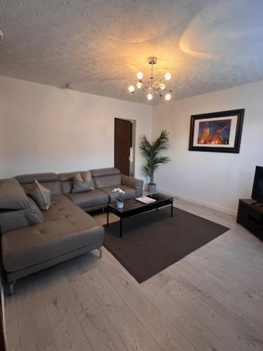 a living room with a couch and a table at Kelpies Serviced Apartments- Russell in Falkirk