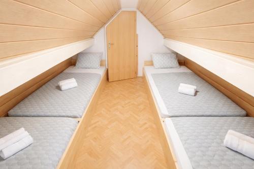 two beds in a small room with wooden floors at Vineyard cottage Hočevar in Novo Mesto
