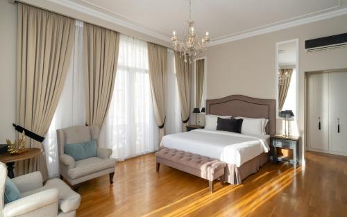 a bedroom with a bed and a chair and a chandelier at EV 11 Athens in Athens