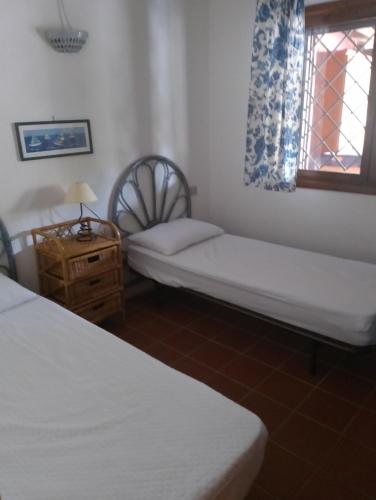 a small room with two beds and a window at Residence Costa Caddu San Teodoro in Porto Ottiolu