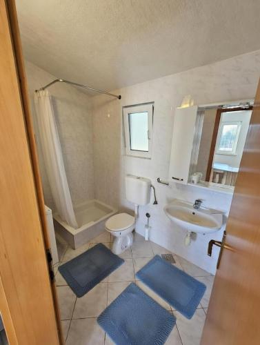 a bathroom with a toilet and a sink and a shower at Perla Mare in Sumartin