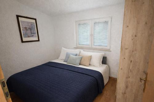 a bedroom with a bed with a blue blanket at Perla Mare in Sumartin