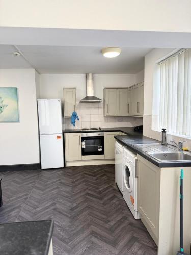 a kitchen with a white refrigerator and a dishwasher at Residency rooms Liverpool in Wallasey